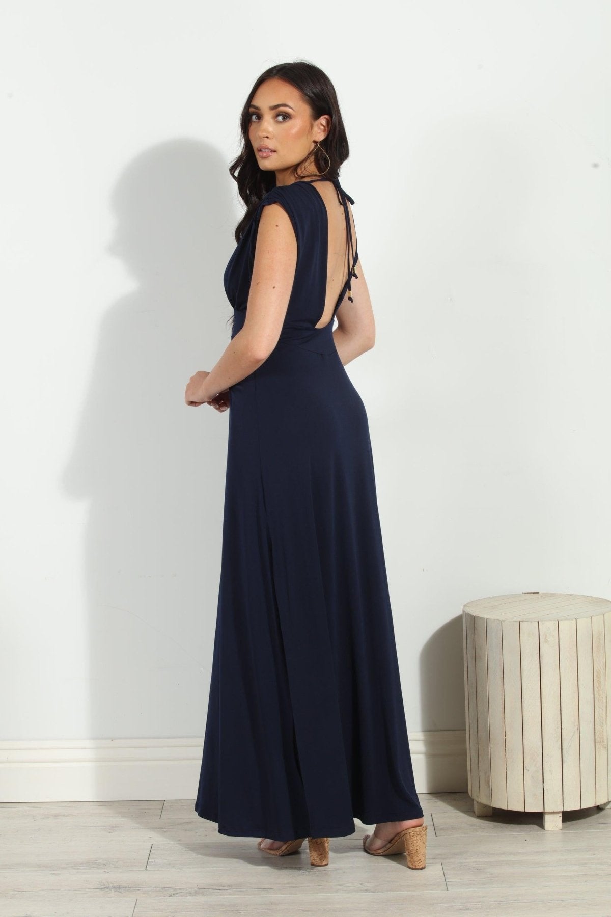 back side of navy sleeveless maxi dress with deep neckline and side slit on woman