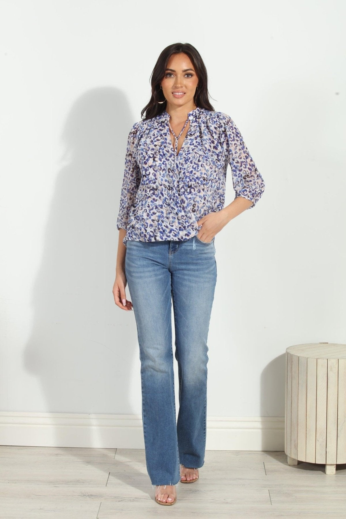 blue and white printed long sleeve blouse on woman in denim pants