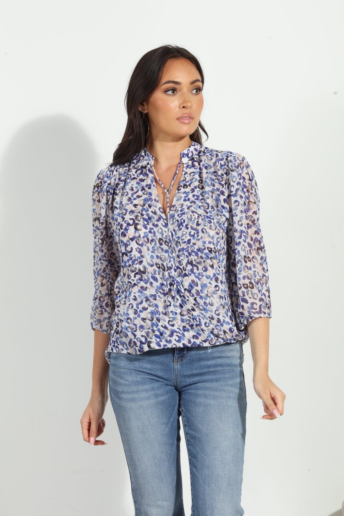 blue and white printed long sleeve blouse on woman in denim pants