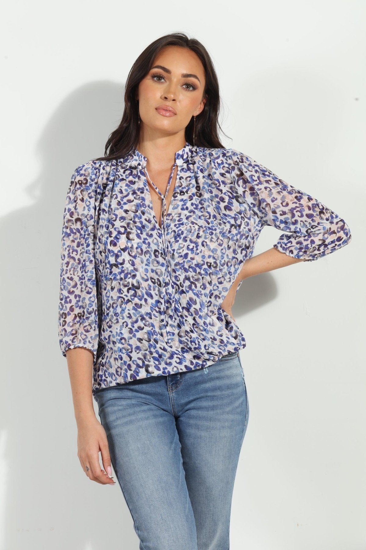 blue and white printed long sleeve blouse on woman in denim pants