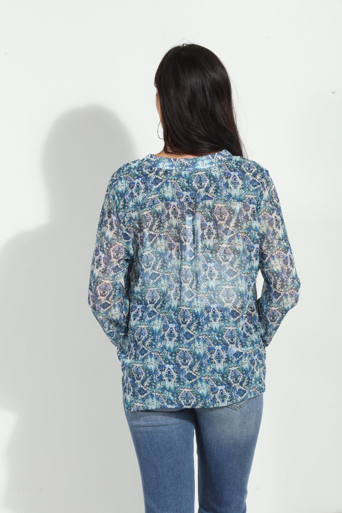 back side of blue printed blouse on woman in denim pants