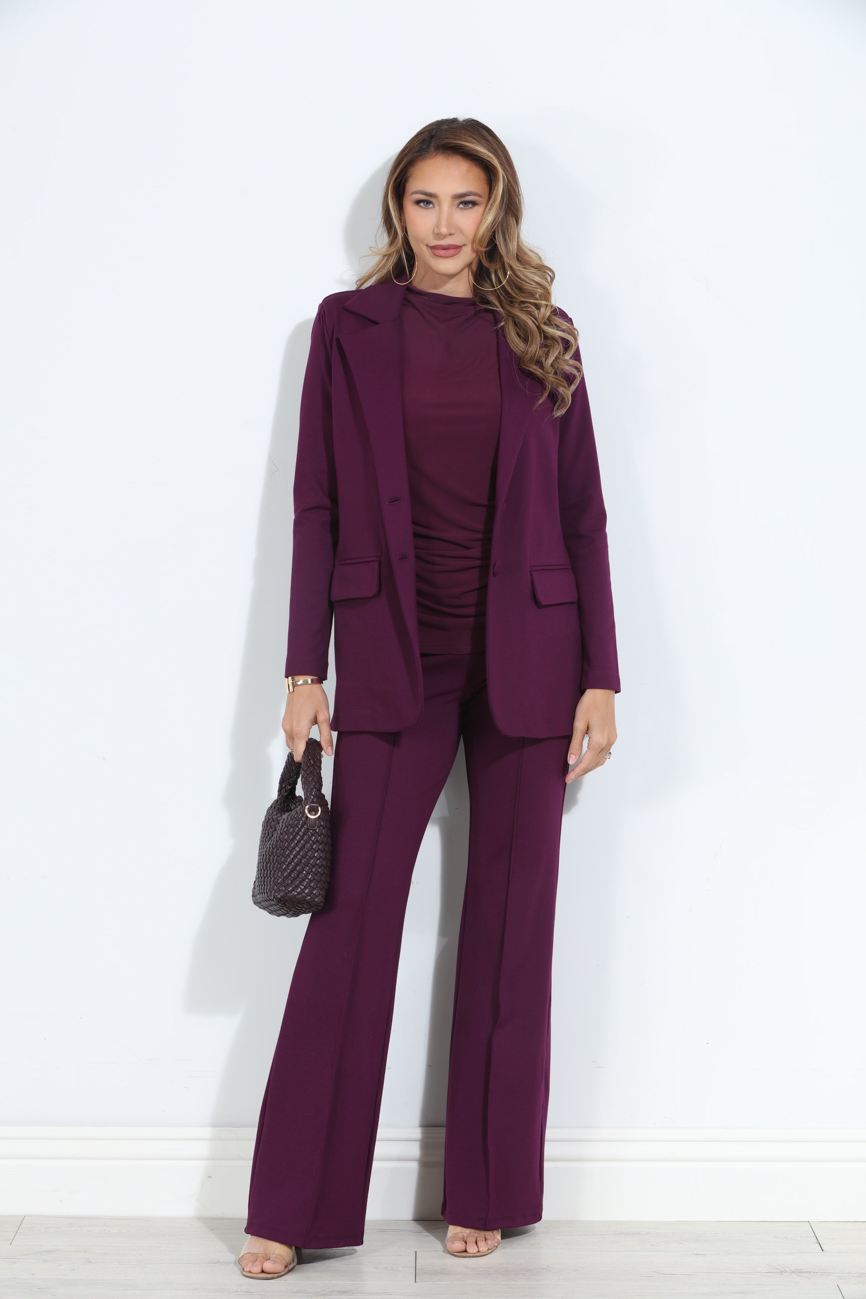 dark purple blazer and pant set on woman holding deep purple purse