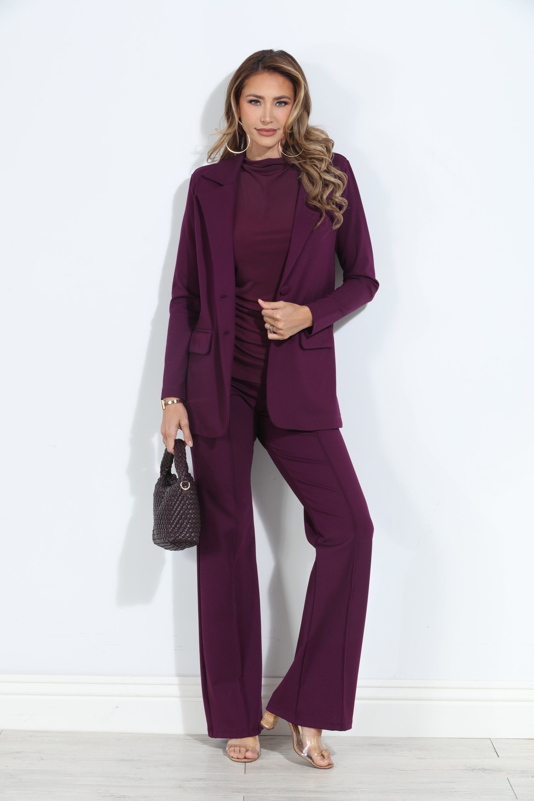 dark purple blazer and pant set on woman holding deep purple purse