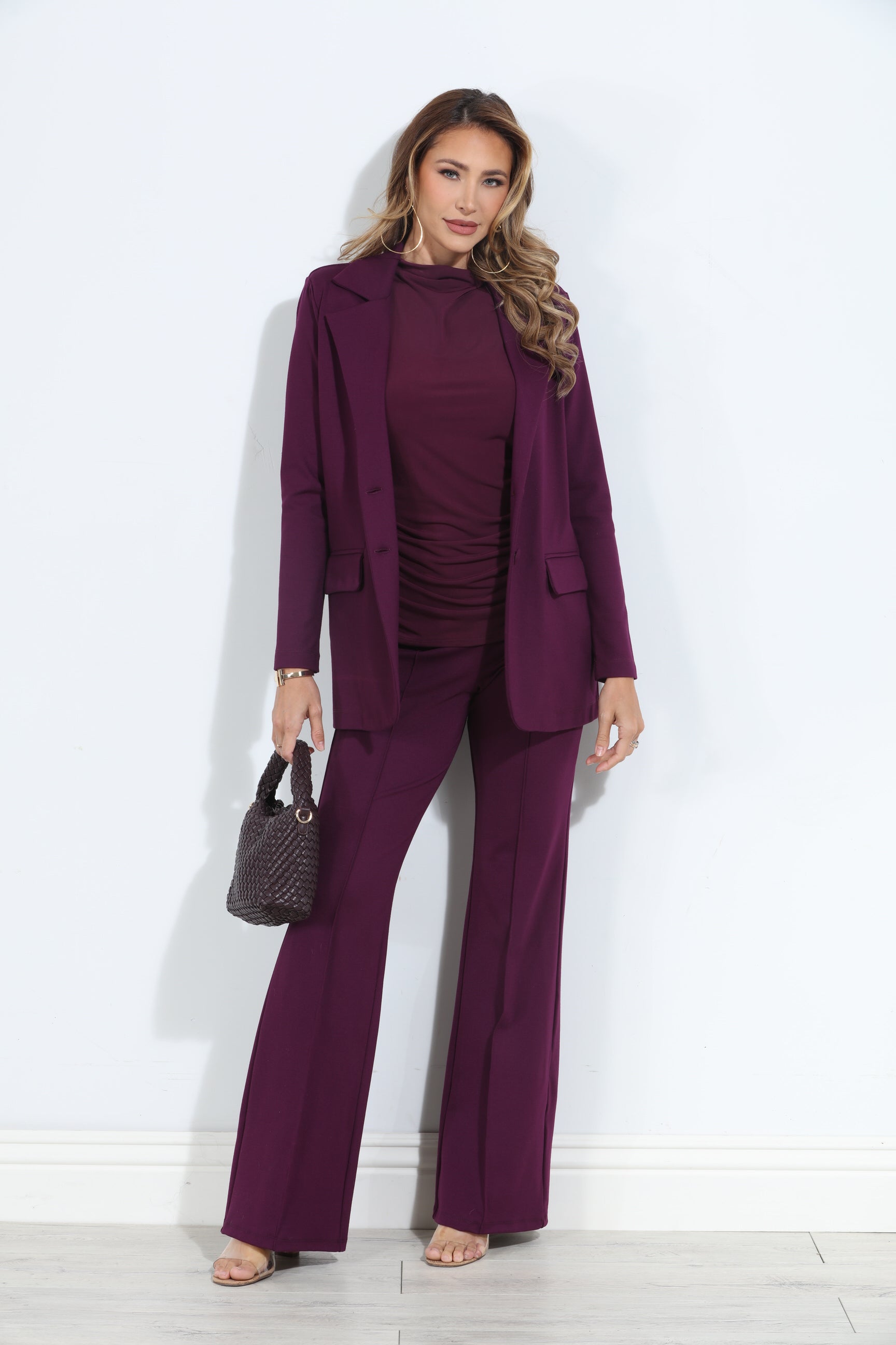 dark purple blazer and pant set on woman holding deep purple purse