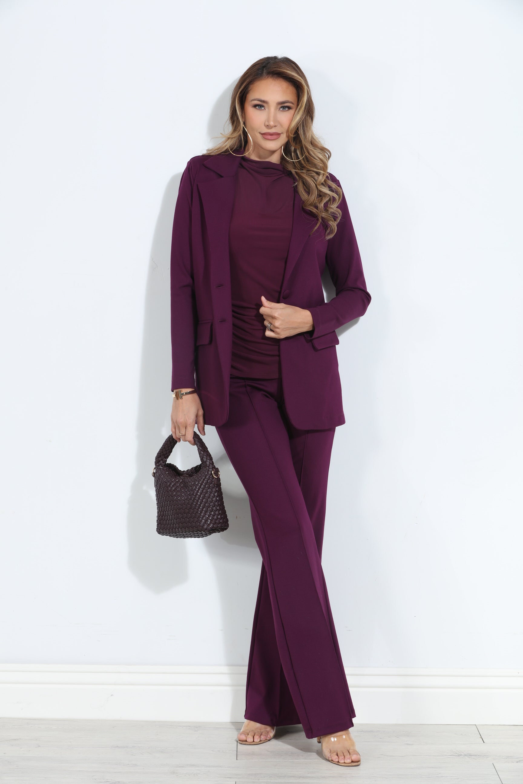 dark purple blazer and pant set on woman holding deep purple purse