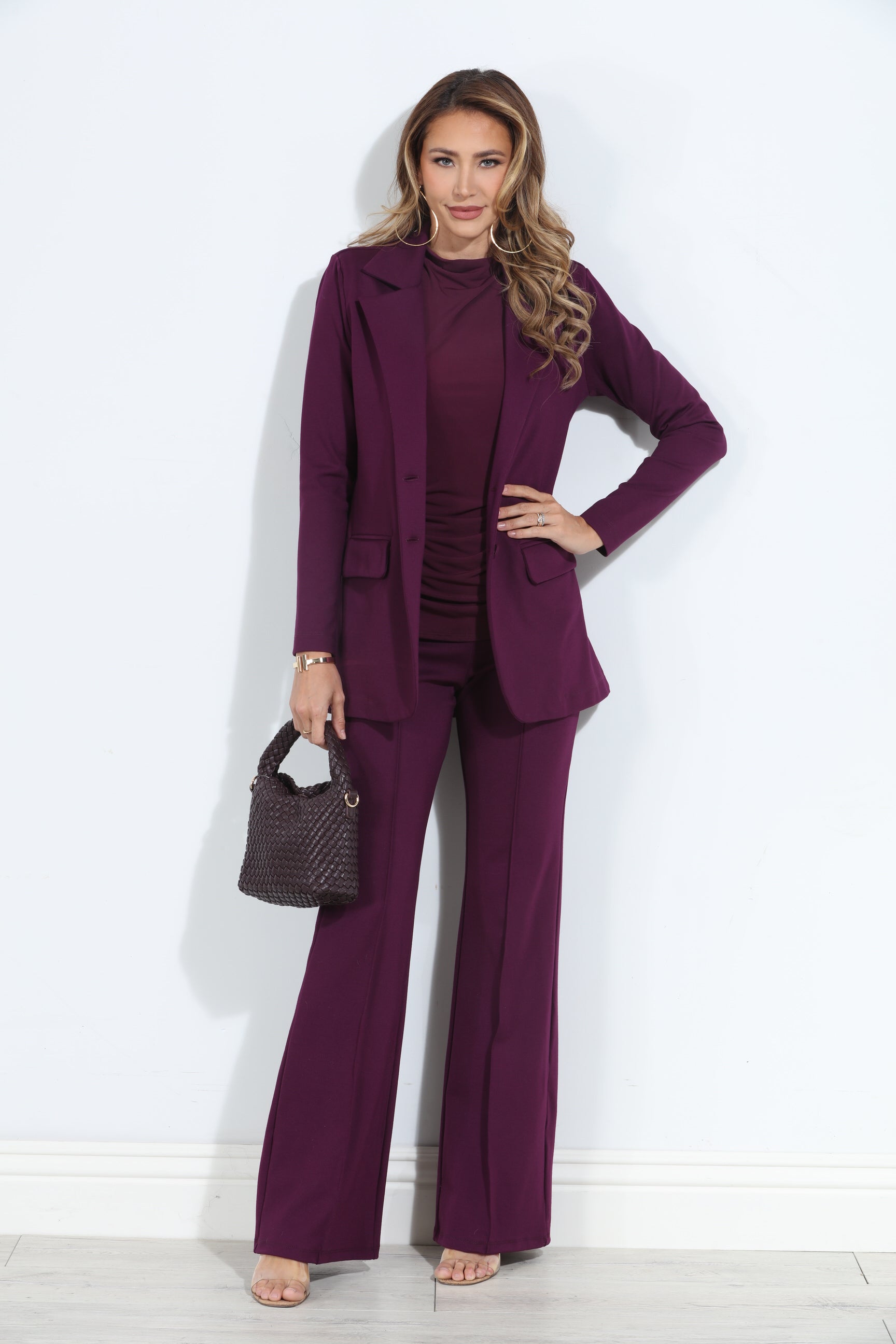 dark purple blazer and pant set on woman holding deep purple purse