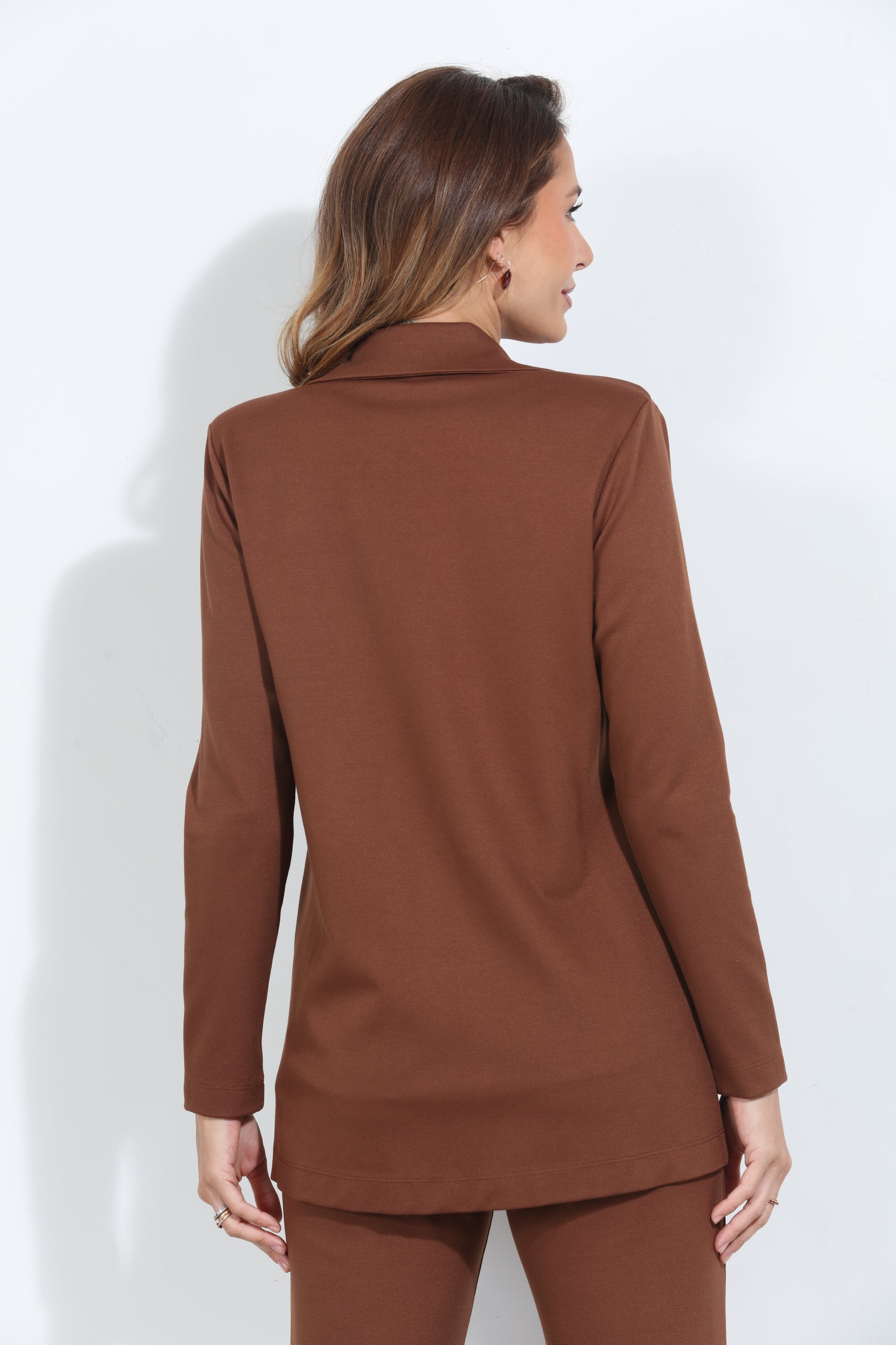 backside of dark orange blazer and pant set on woman