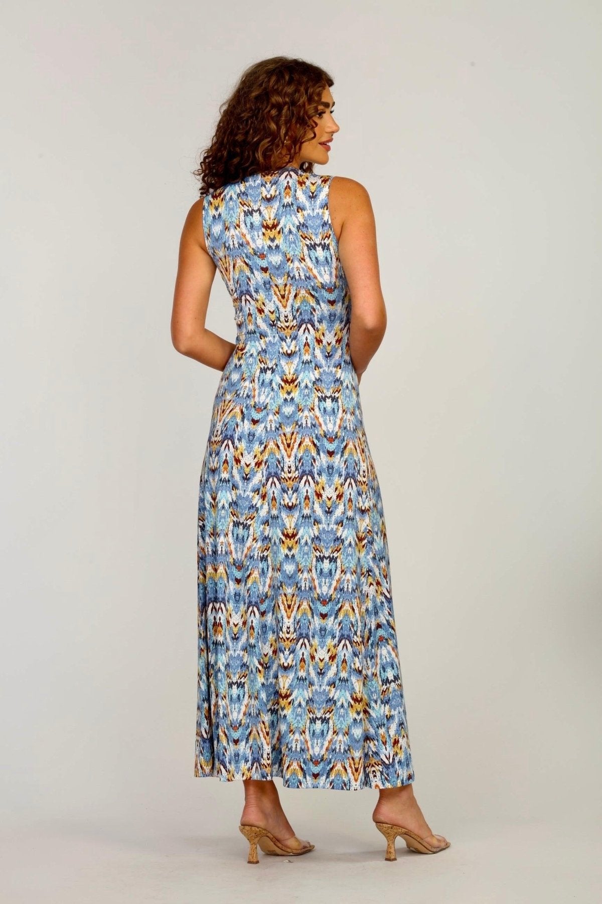 backside of woman with curly hair wearing multicolored maxi dress