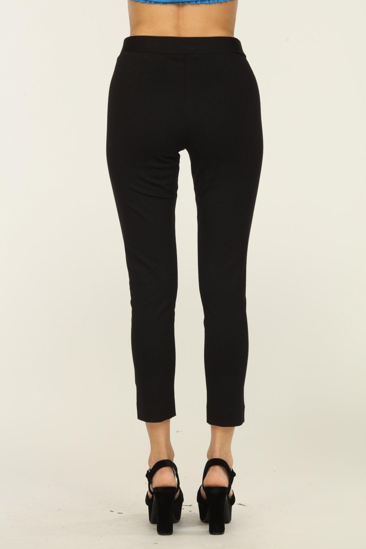 back side of black tapered pants on woman in black heels