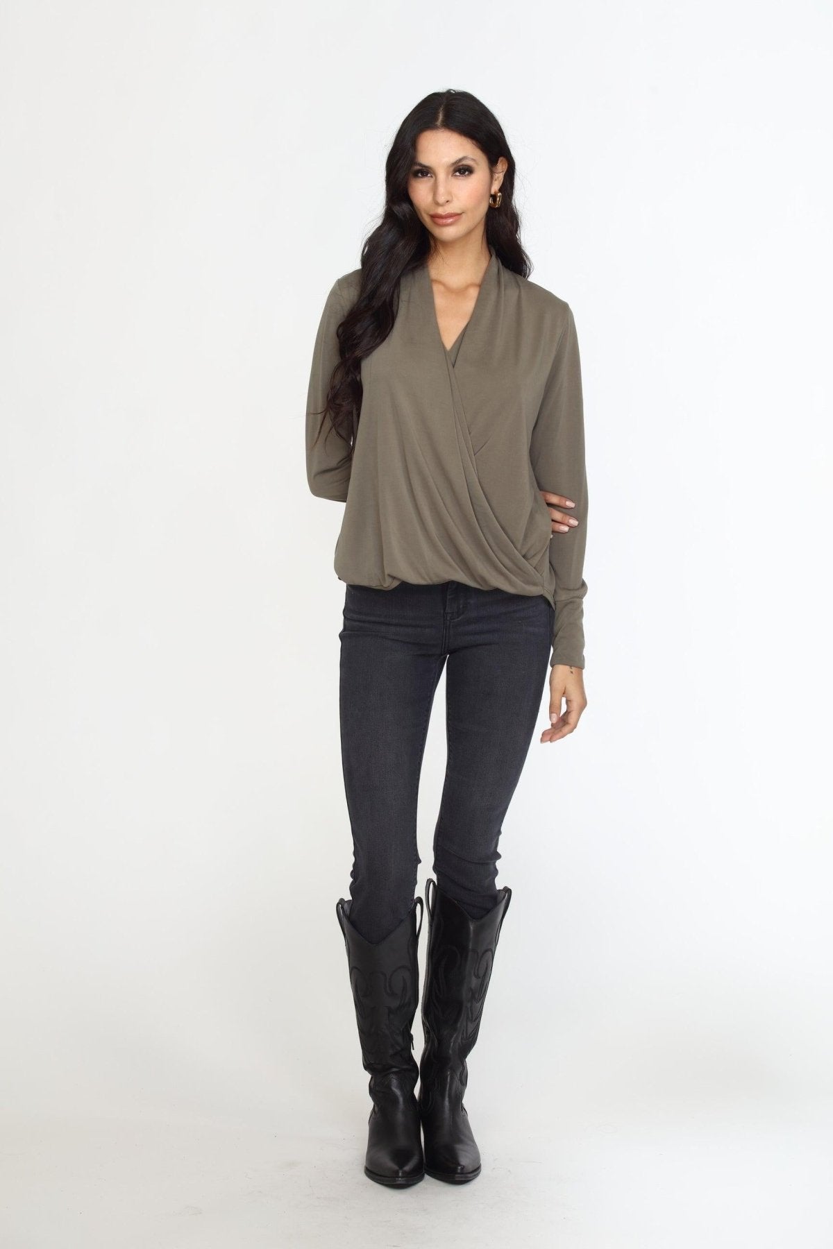 olive long sleeve draped blouse on woman in dark denim pants and black boots