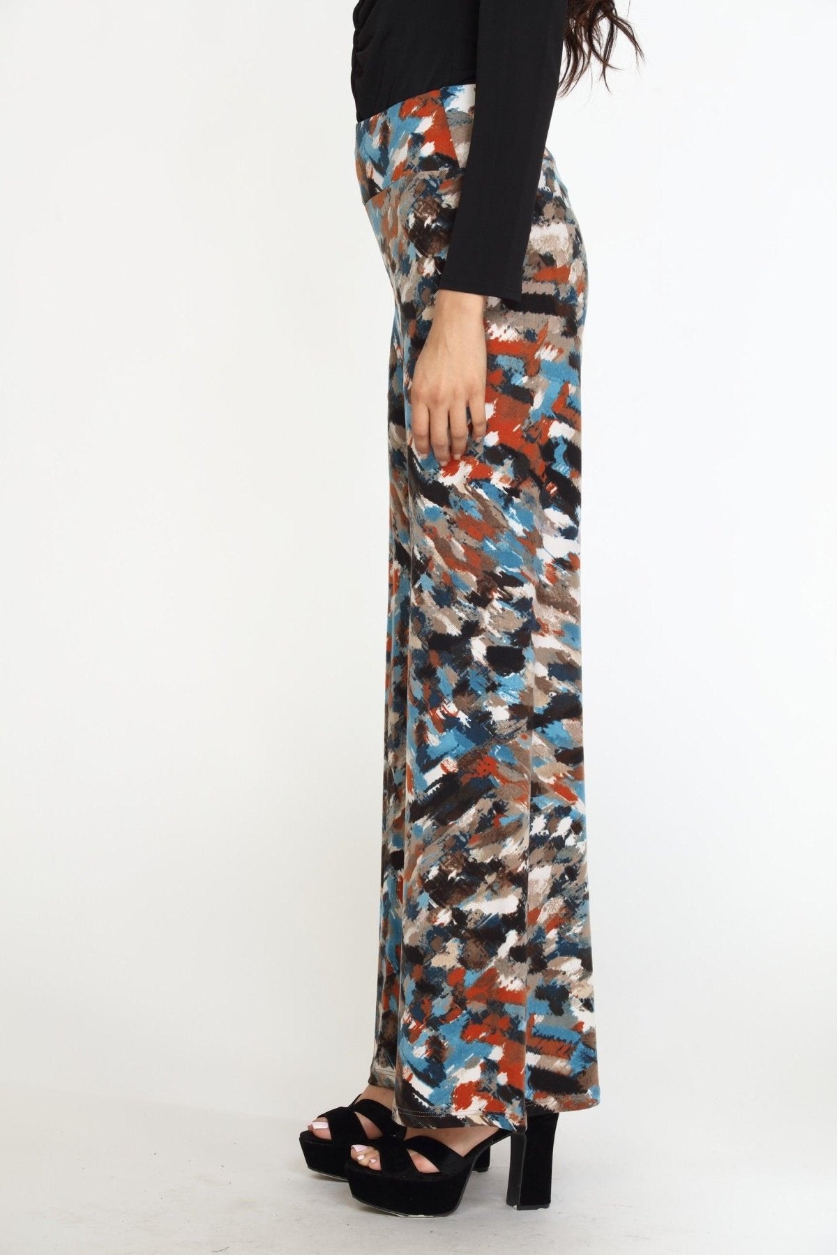 side view of multicolored wideleg pants on woman in black heels and black long sleeve top