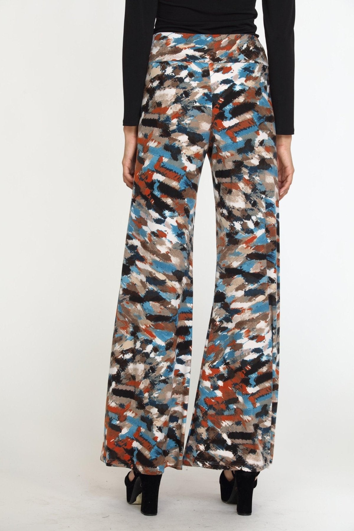 back side of multicolored wideleg pants on woman in black heels and black long sleeve top