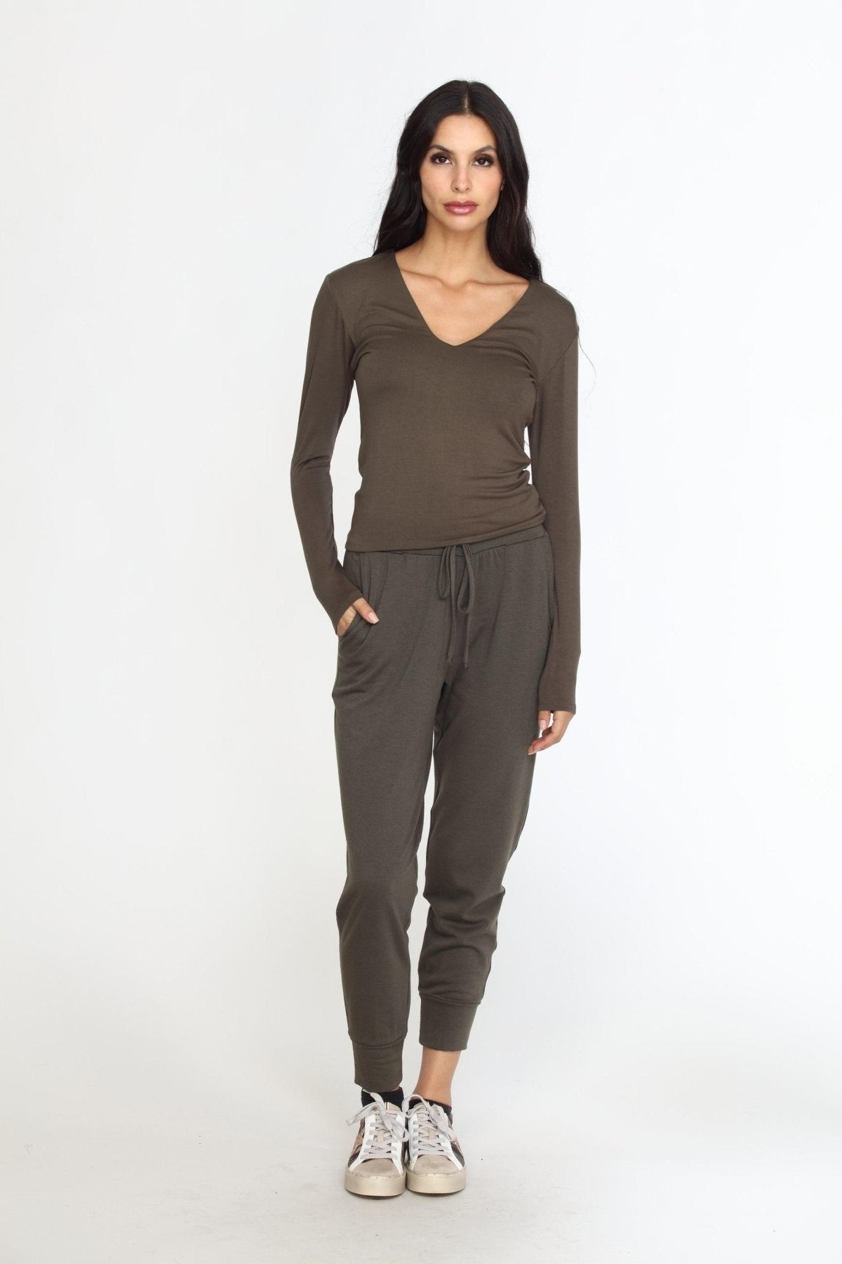 olive long sleeve vneck top on woman in olive pants and tennis shoes