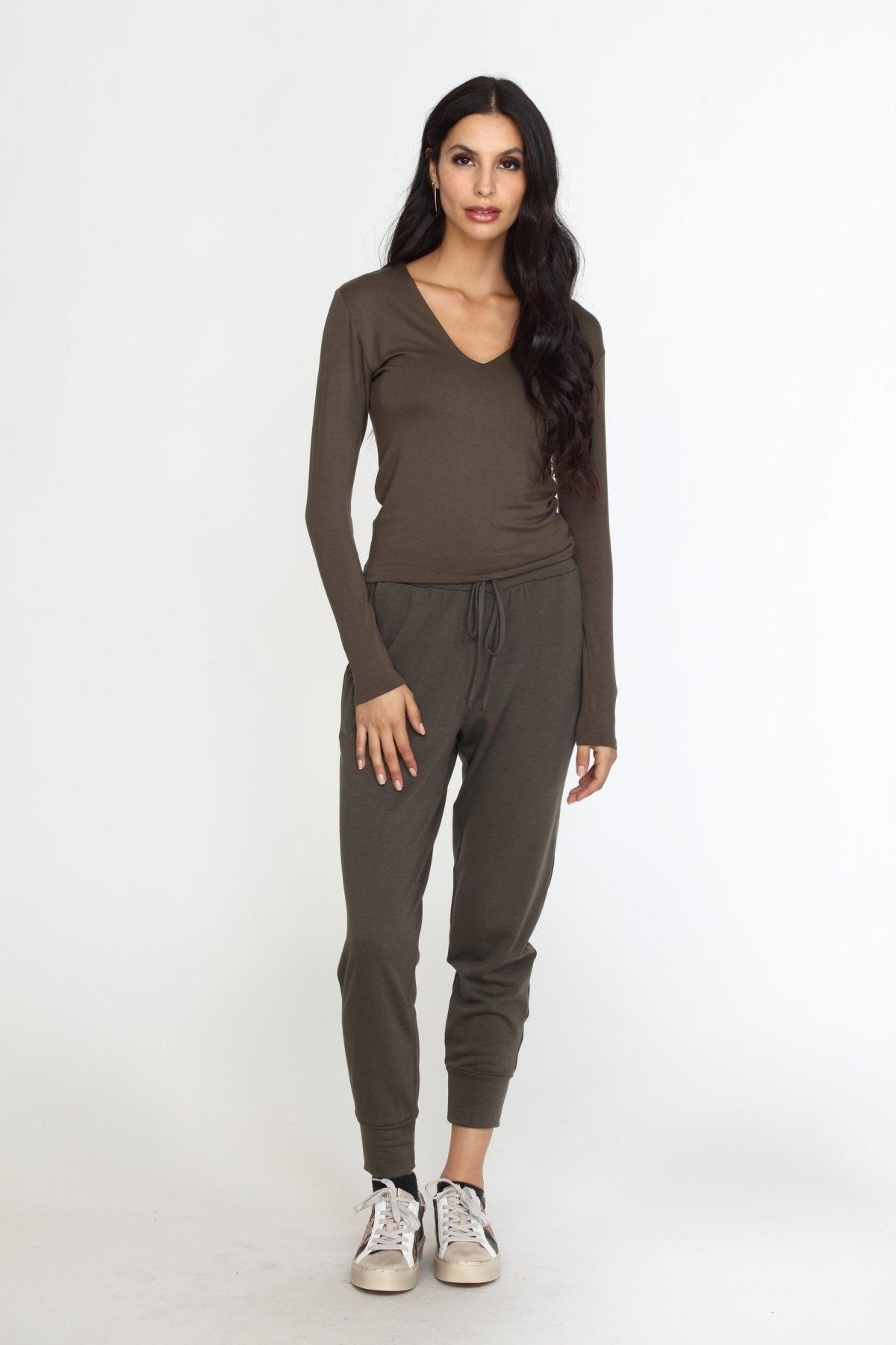 olive long sleeve vneck top on woman in olive pants and tennis shoes