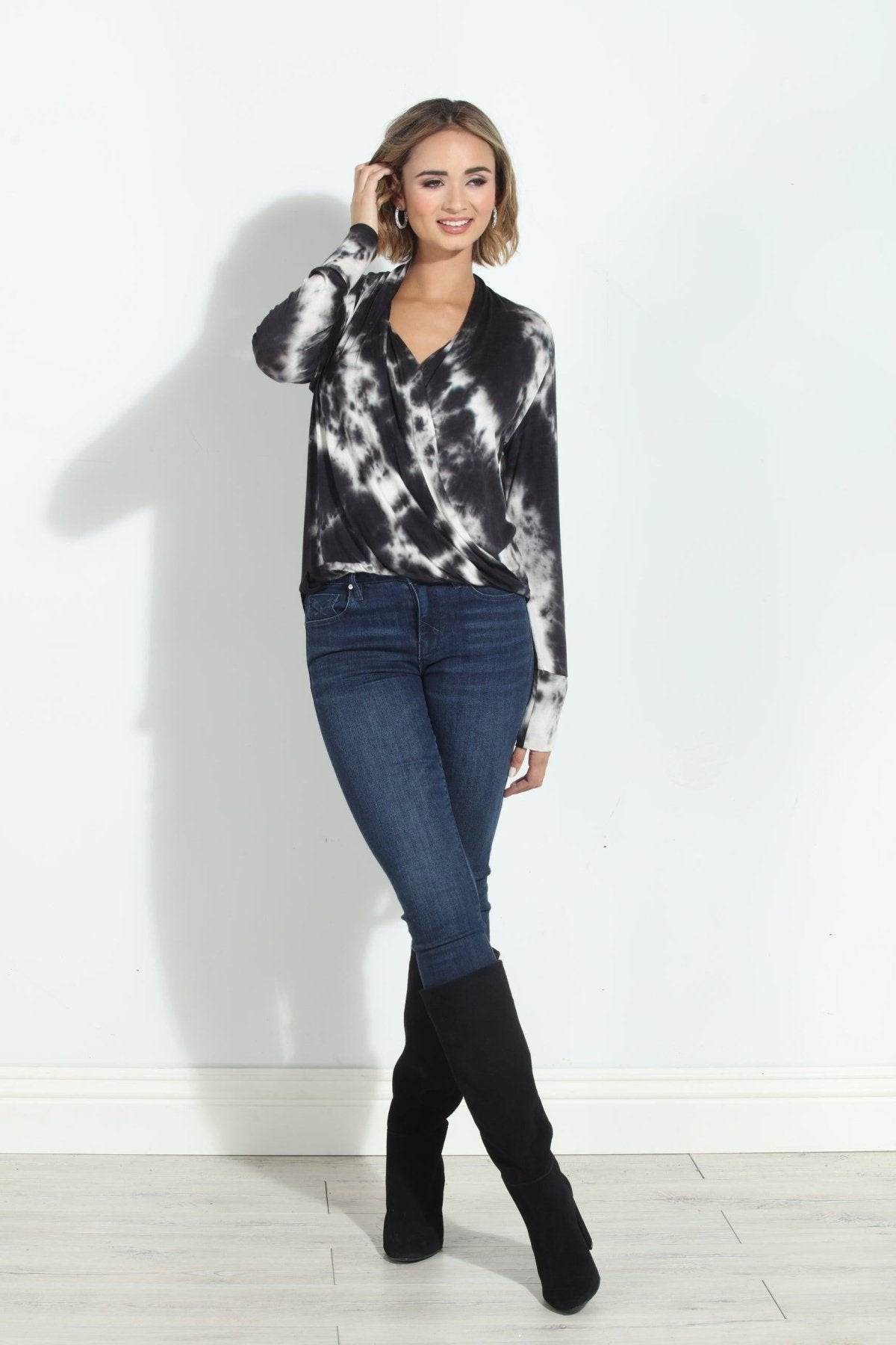 black and white tie-died long sleeve blouse on woman in denim pants and black boots
