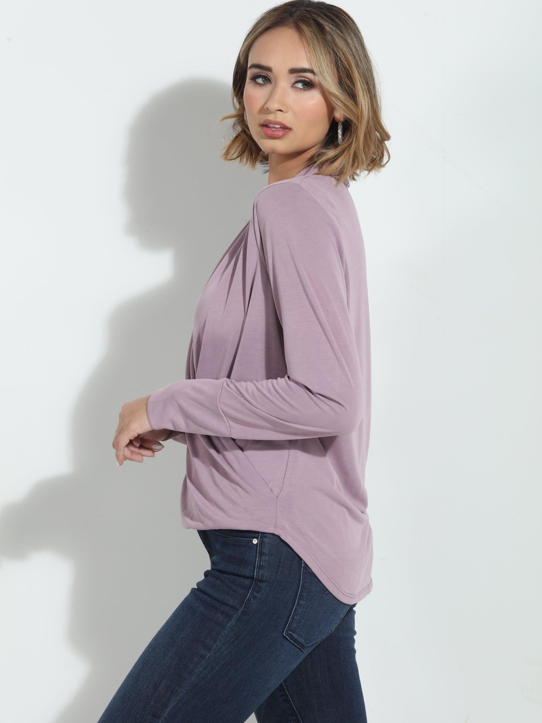 size angle of pink long sleeve blouse on woman in denim pants