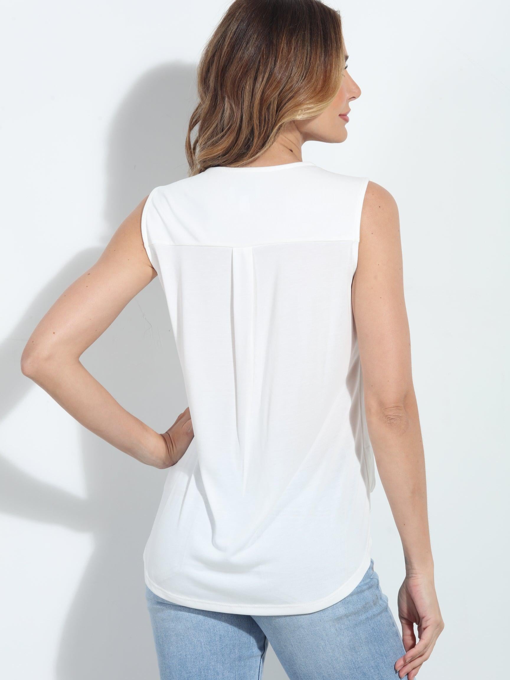 backside of ivory sleeveless blouse on woman in denim pants