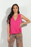 hot pink sleeveless top on woman in multicolored pants