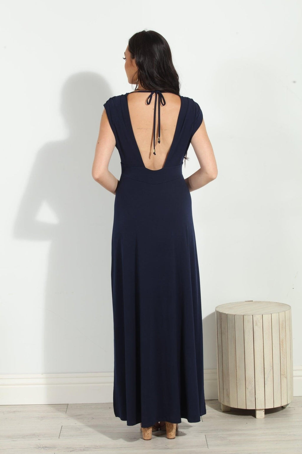 back side of navy sleeveless maxi dress with deep neckline and side slit on woman