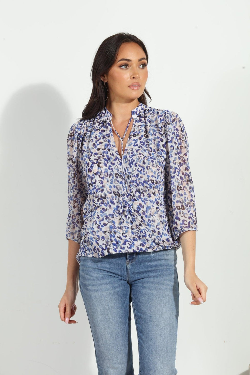 blue and white printed long sleeve blouse on woman in denim pants