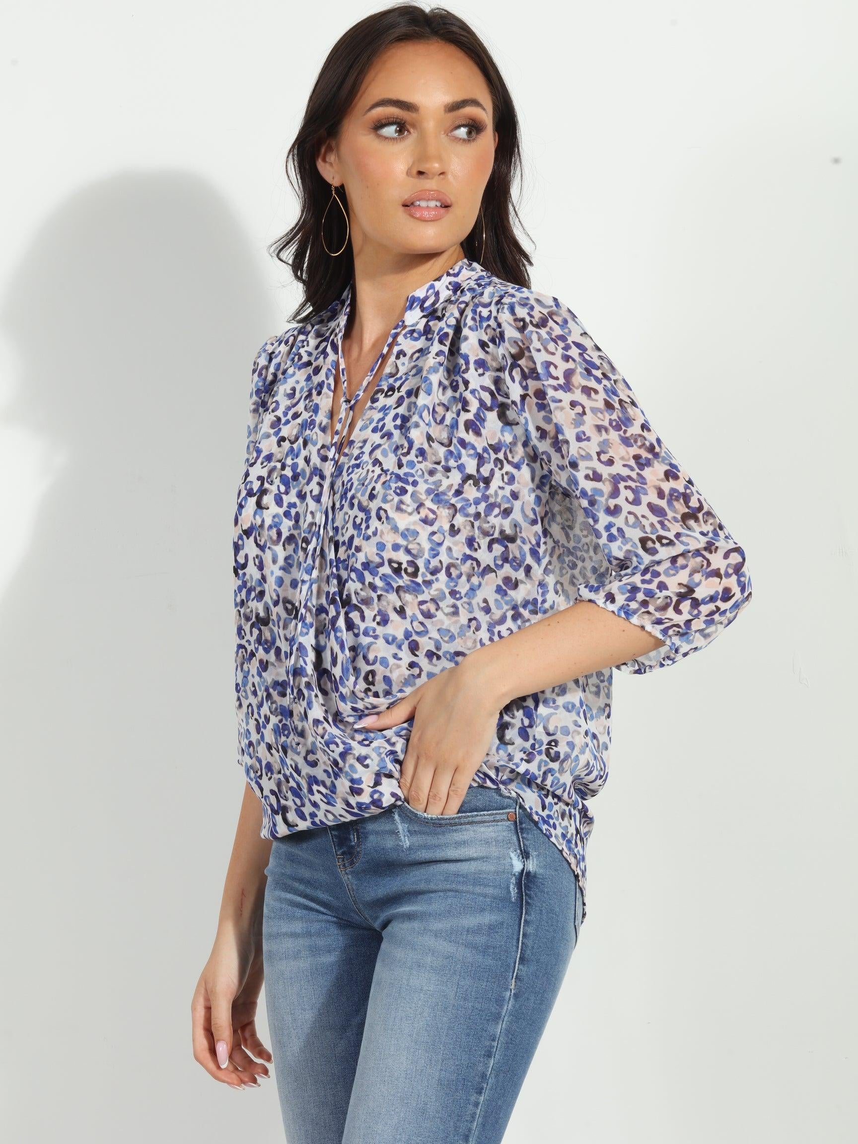 blue and white printed long sleeve blouse on woman in denim pants