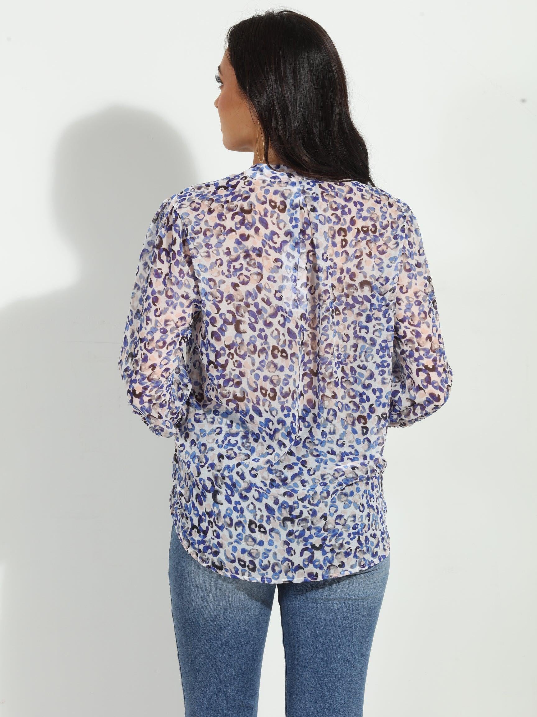back side of blue and white printed long sleeve blouse on woman in denim pants