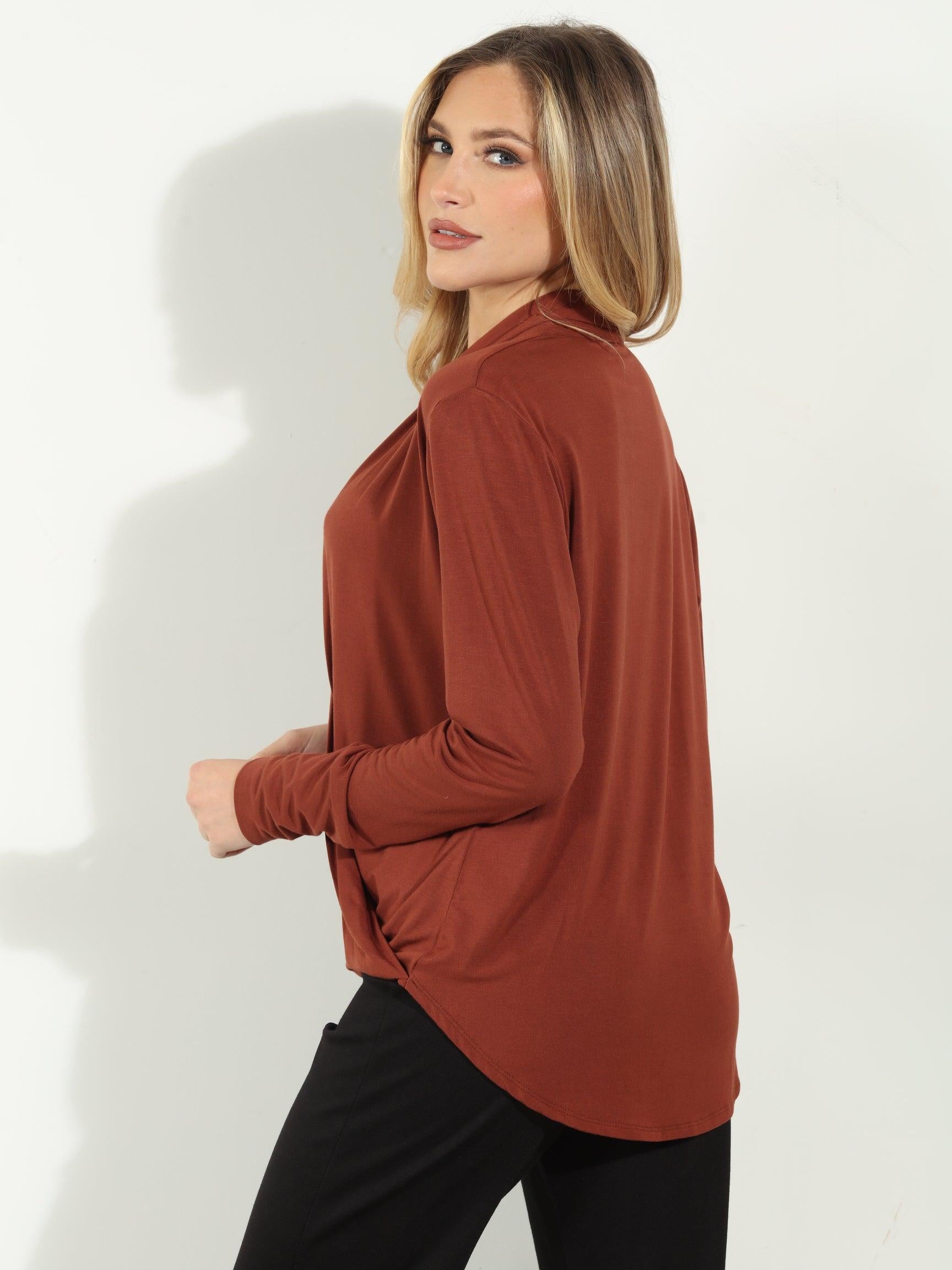 back side of dark orange long sleeve blouse on woman in black pants
