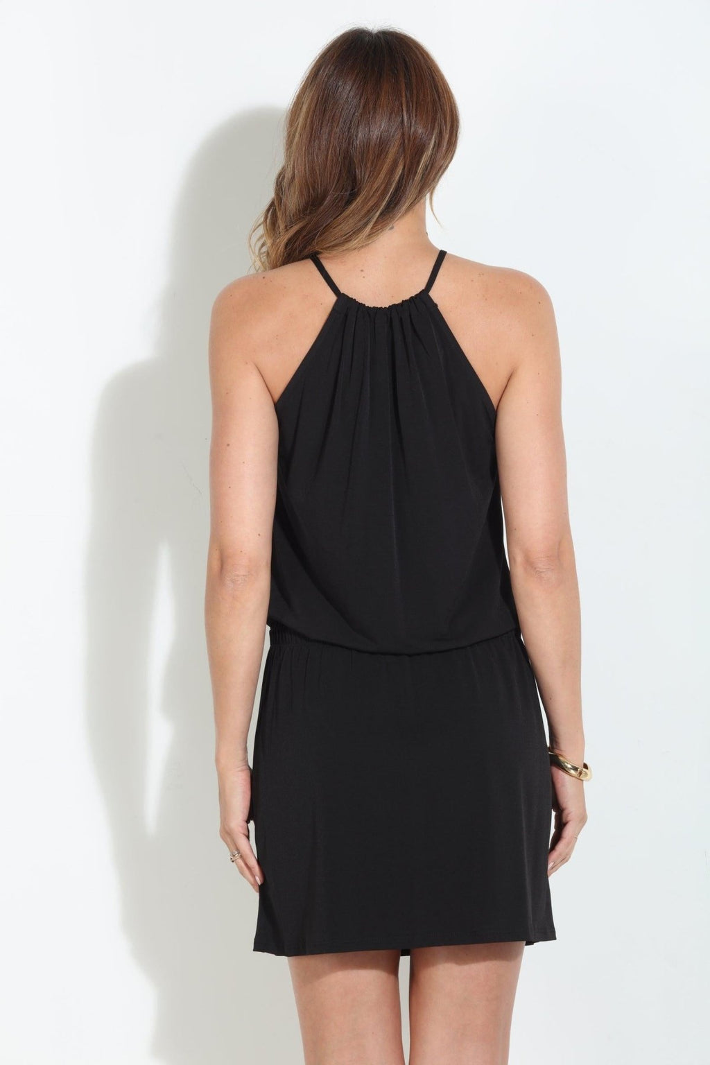 back side view of black sleeveless halter dress on woman