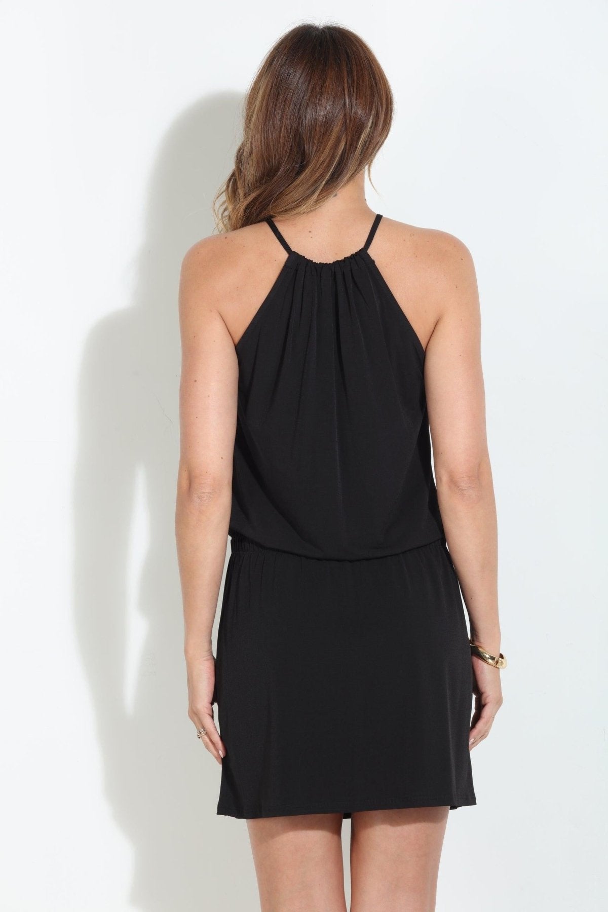 back side view of black sleeveless halter dress on woman