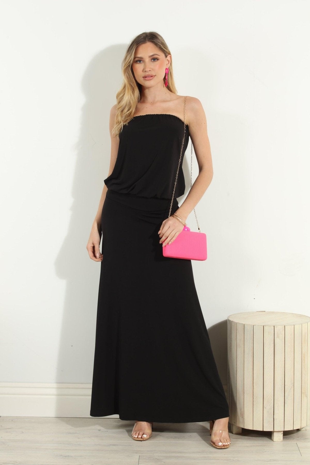 black strapless maxi dress on woman holding pink purse