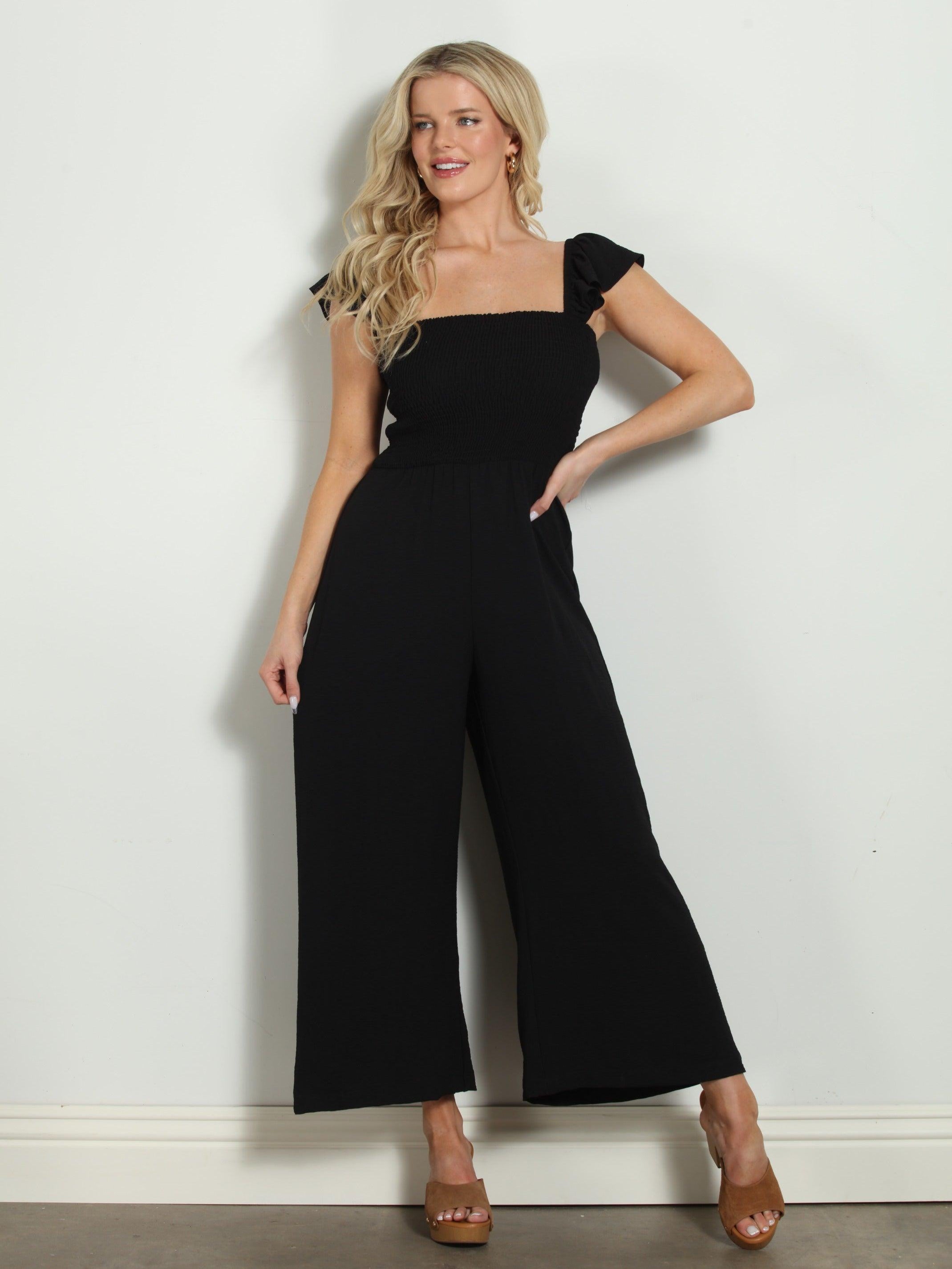 black sleeveless jumpsuit styled on woman in tan colored heels