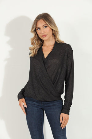 black and sparkle long sleeve blouse on woman in denim pants