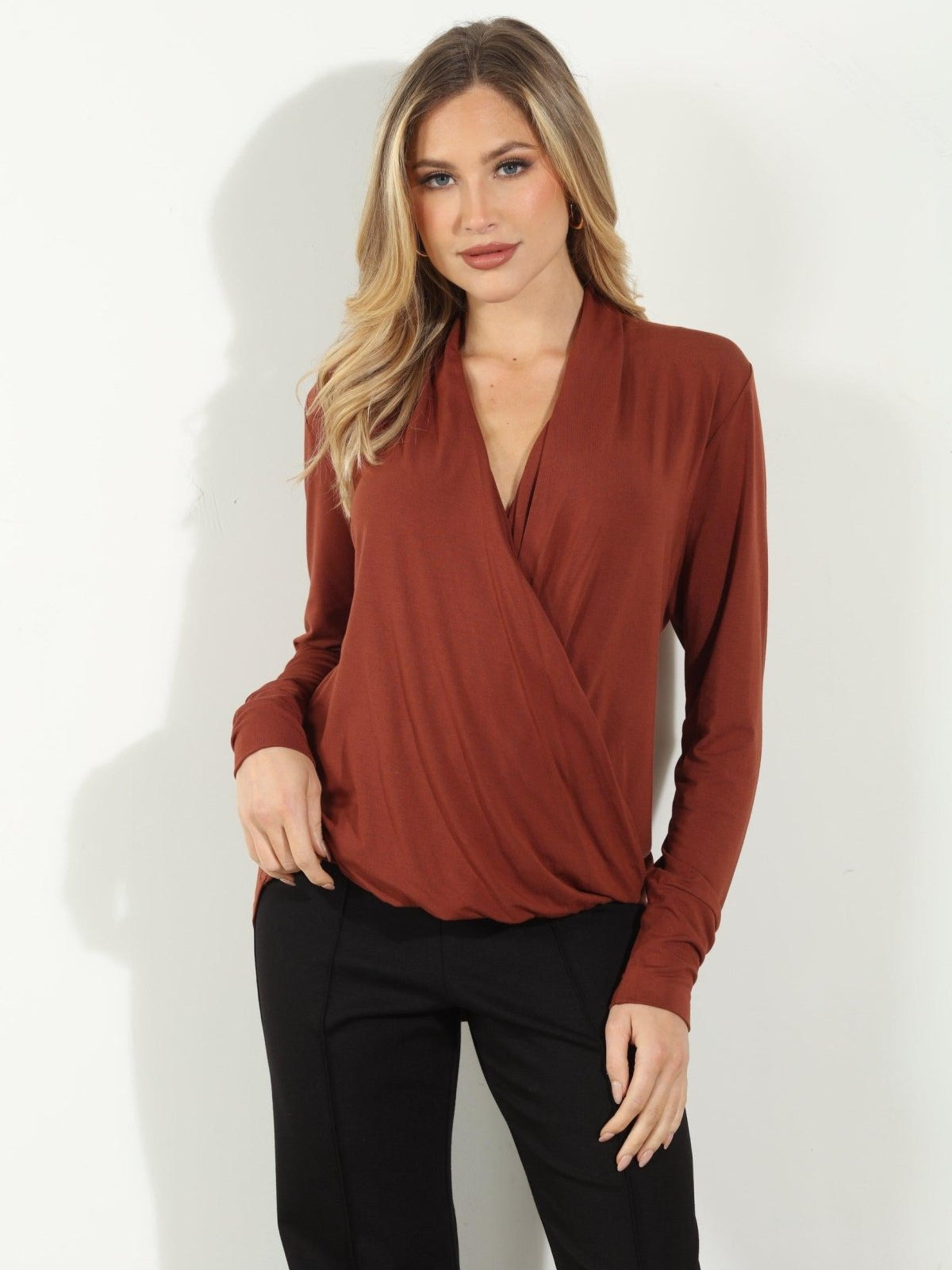 dark orange long sleeve blouse on woman in black pants