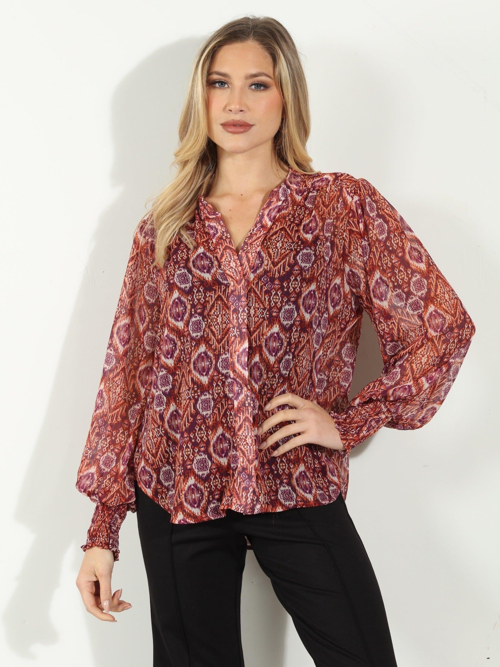 woman in printed long-sleeve blouse and black pants