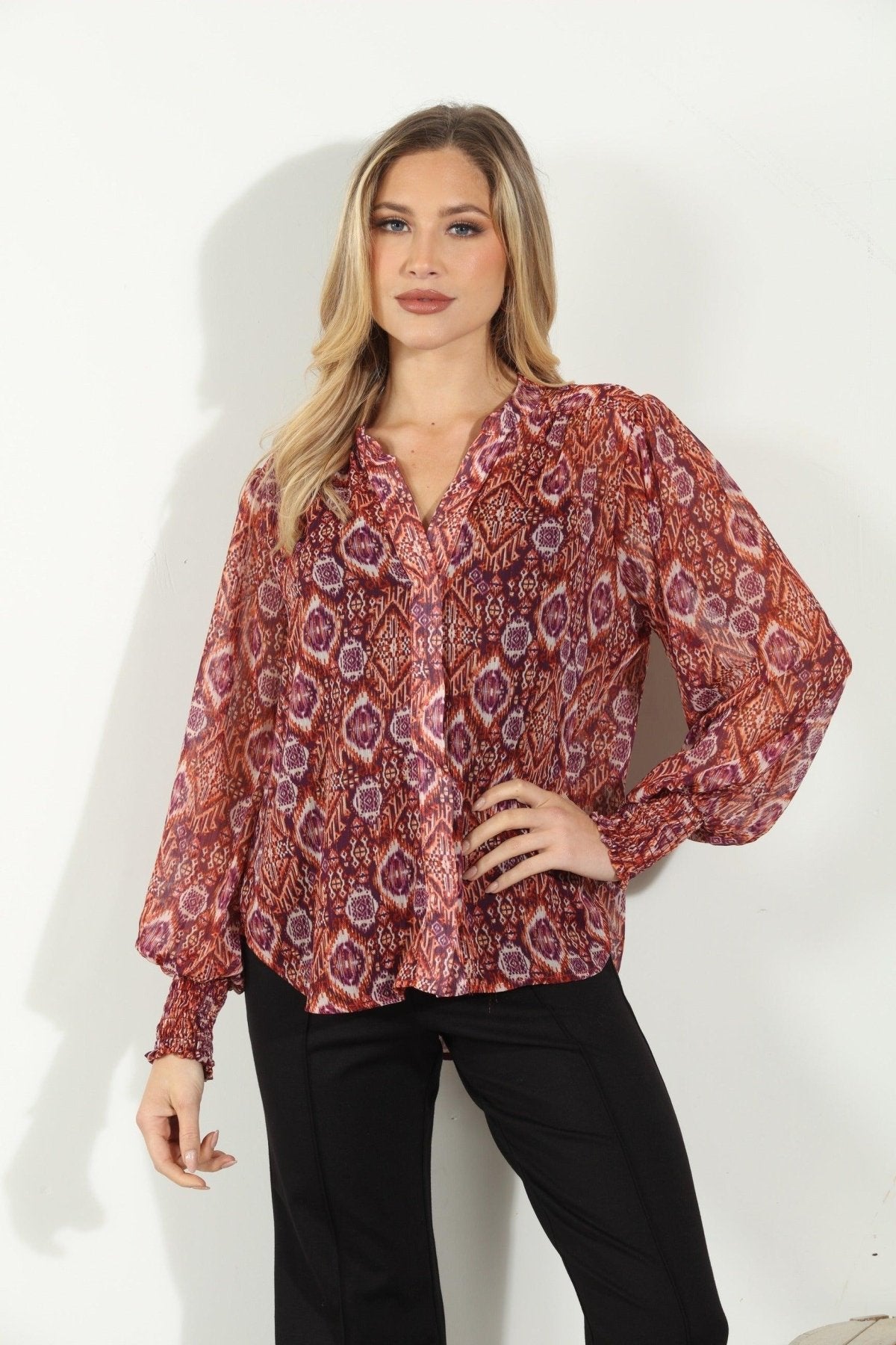 woman in printed long-sleeve blouse and black pants
