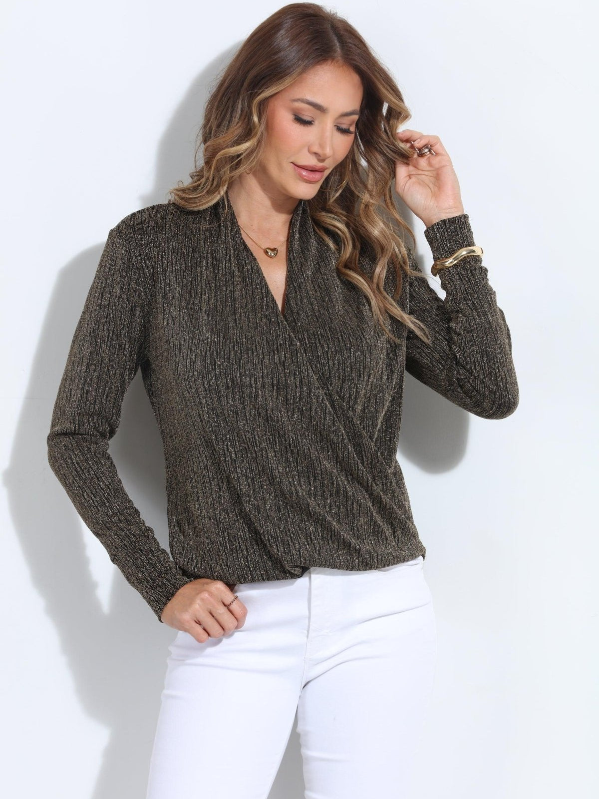 black and gold long sleeve top on woman in white pants