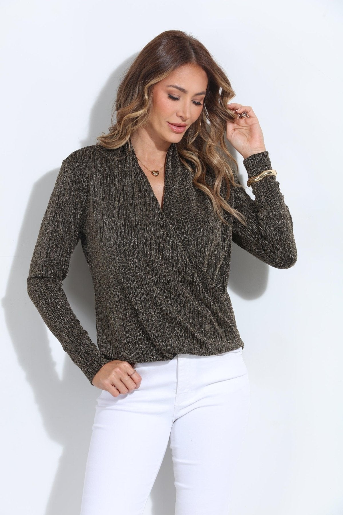 black and gold long sleeve top on woman in white pants