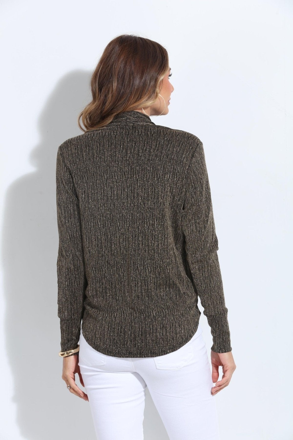 backside of black and gold long sleeve top on woman in white pants