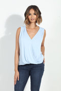 light blue sleeveless top on woman in denim pants