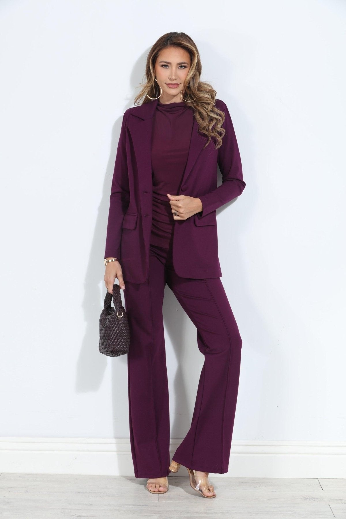 dark purple blazer and pant set on woman holding deep purple purse