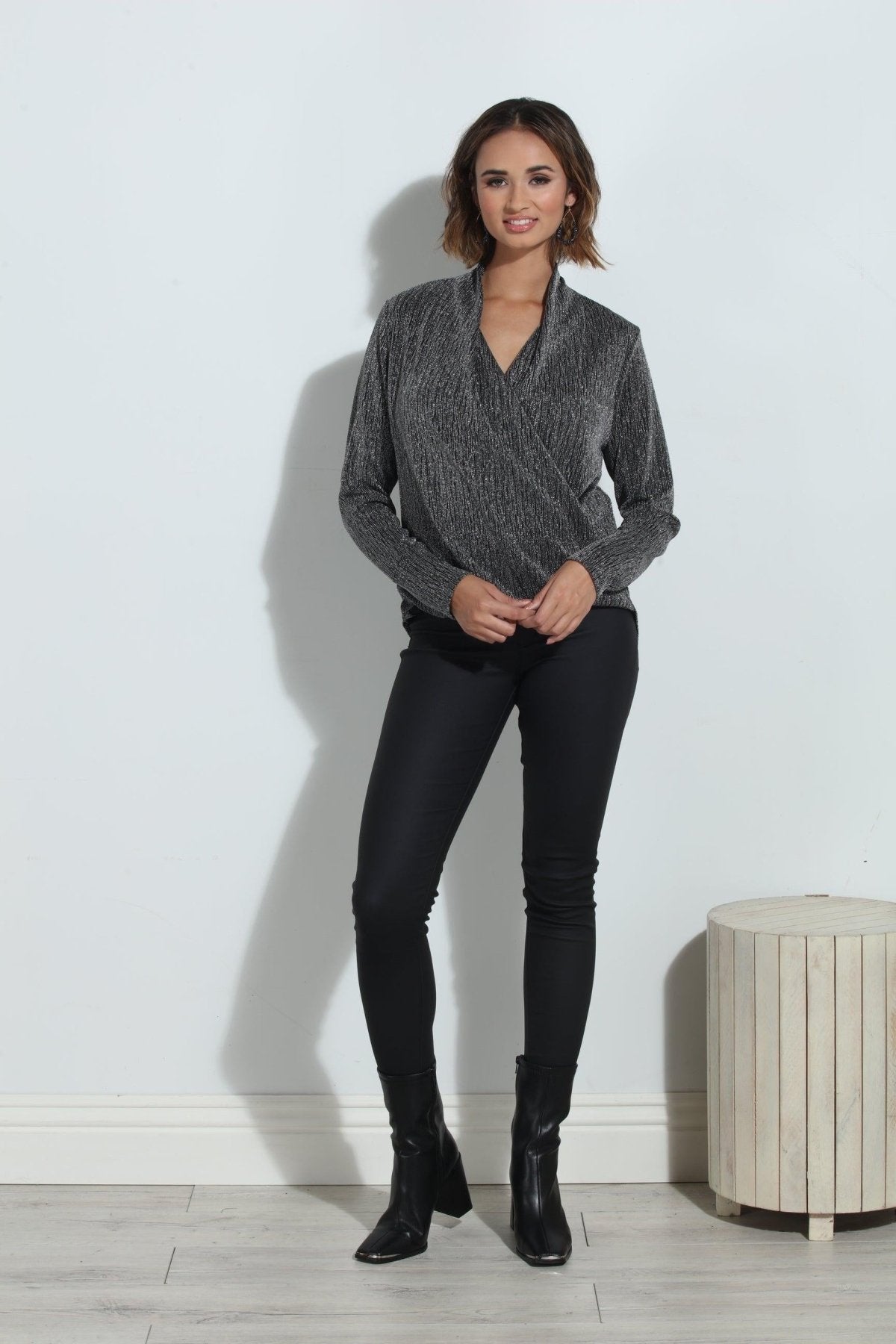 silver and black long sleeve blouse on woman in black pants and black boots