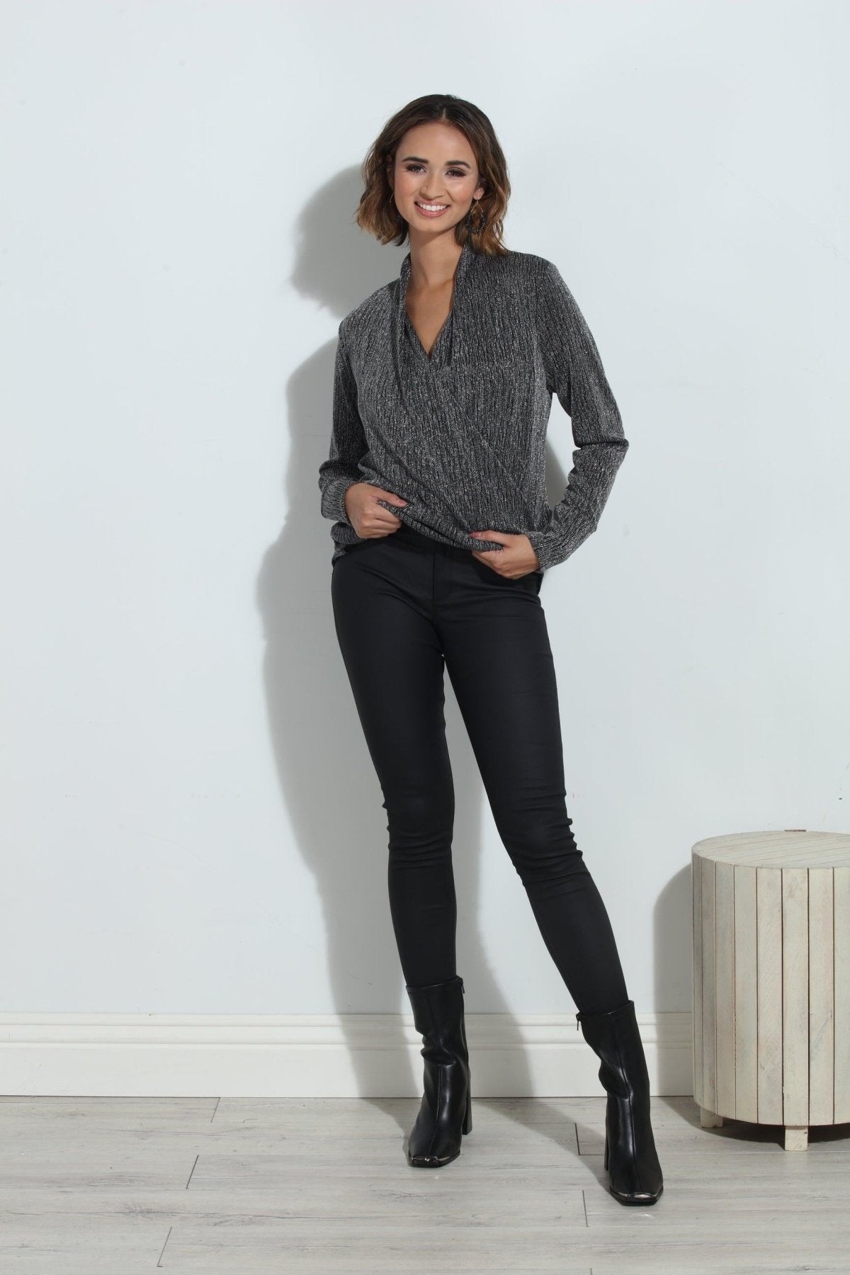 silver and black long sleeve blouse on woman in black pants and black boots