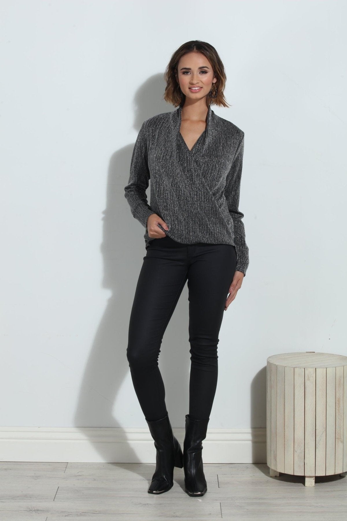 silver and black long sleeve blouse on woman in black pants and black boots