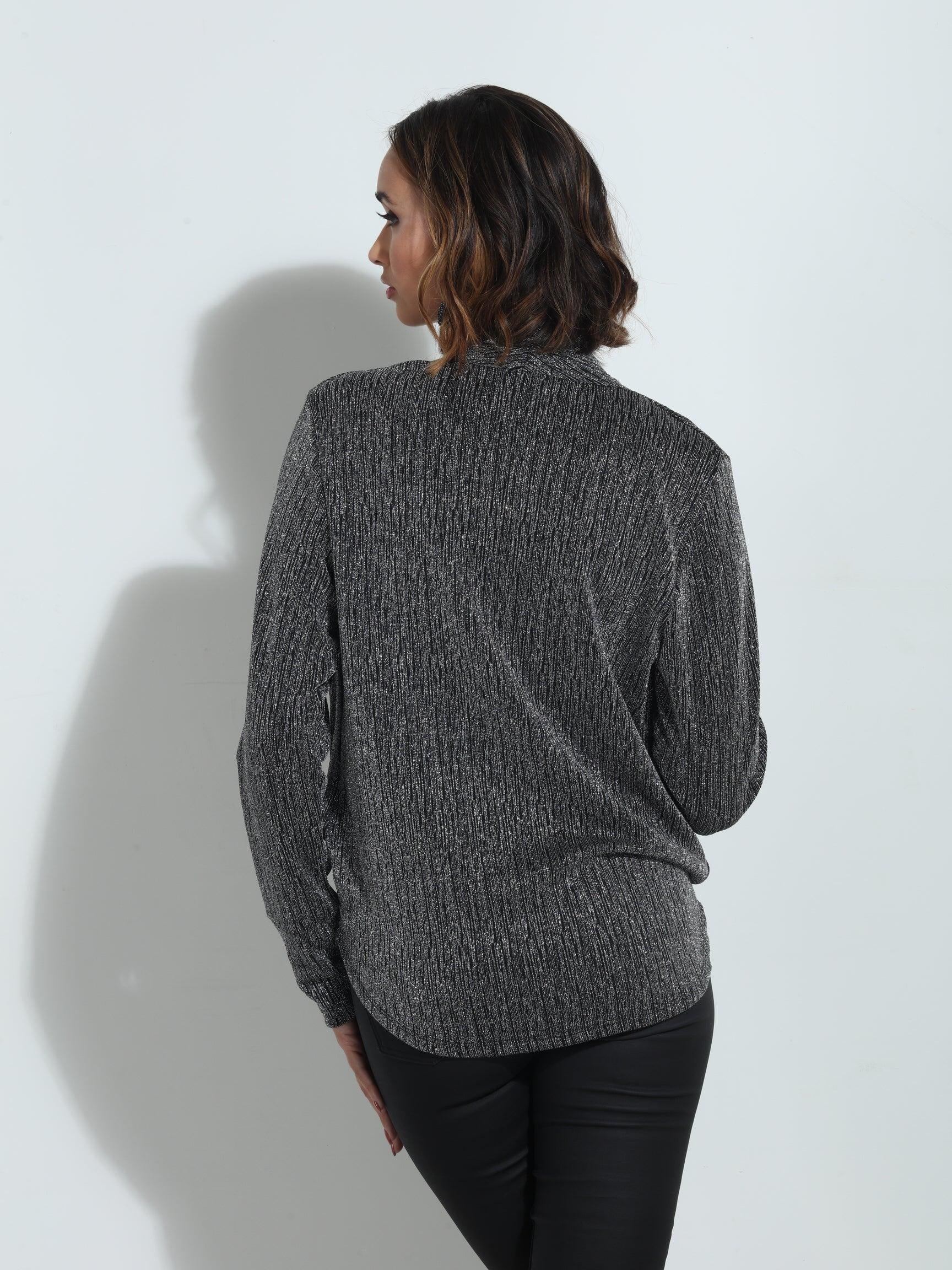 backside of silver and black long sleeve blouse on woman in black pants