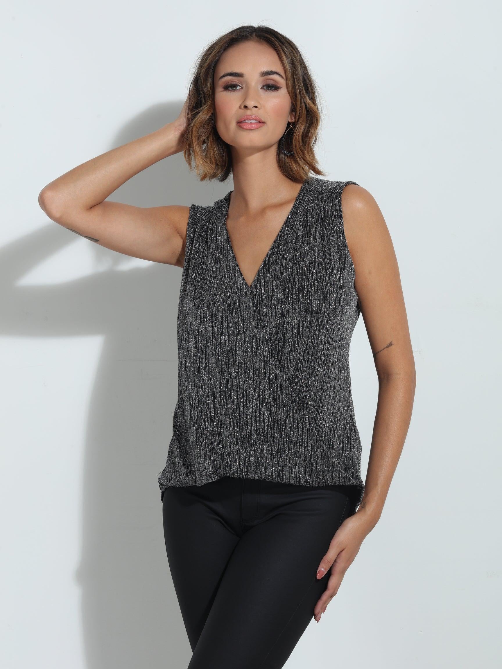 silver sparkle sleeveless blouse on woman in black pants