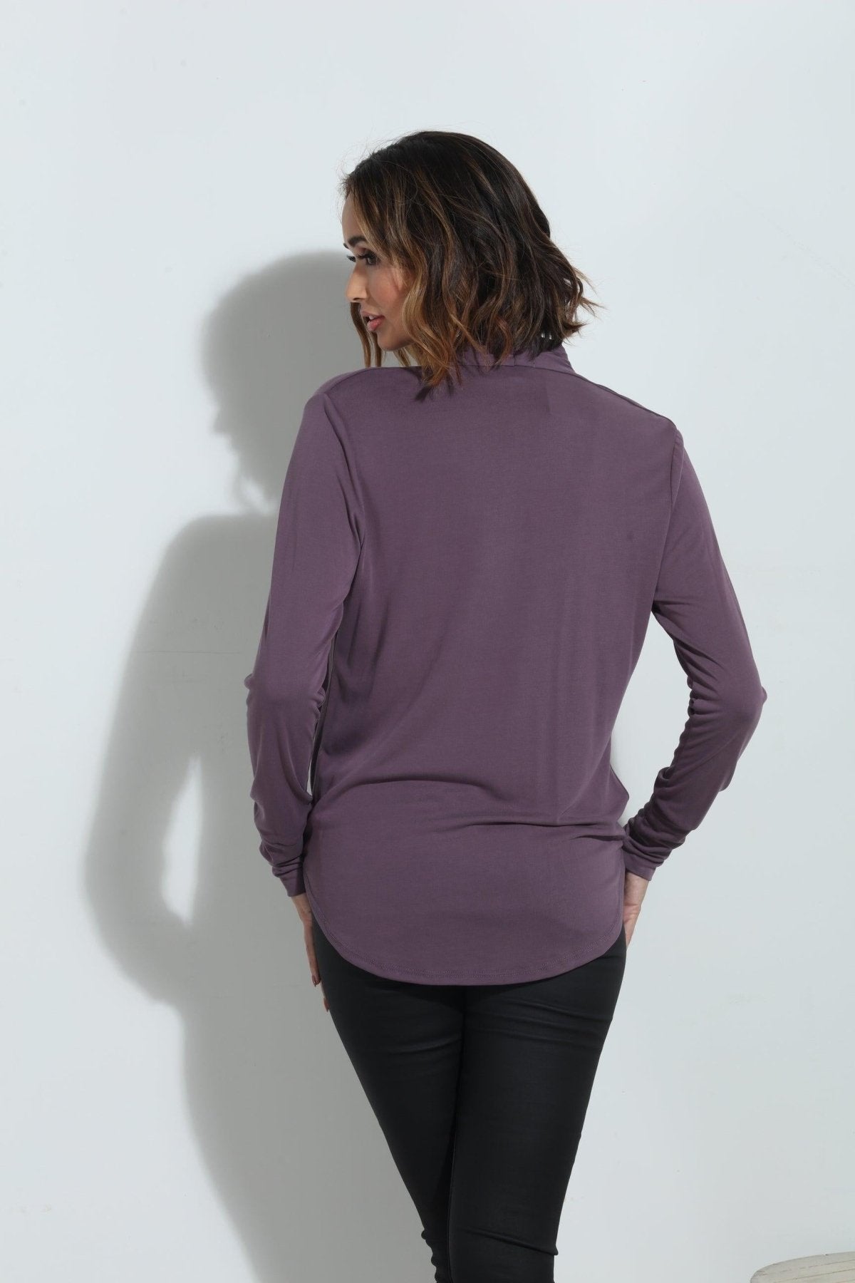 back side of purple long sleeve blouse on woman in black pants
