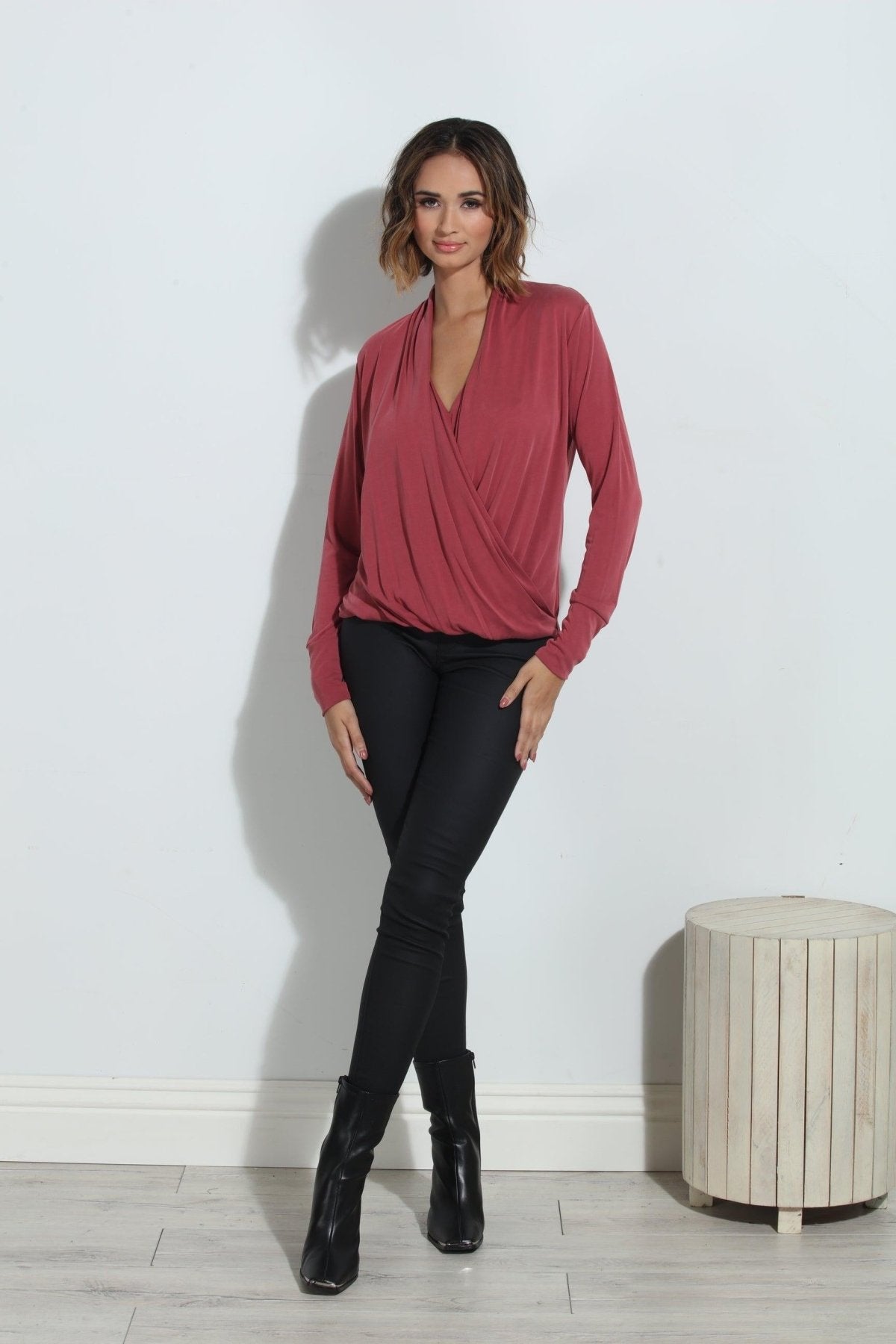 dark mauve long sleeve blouse on woman in dark denim pants and black boots