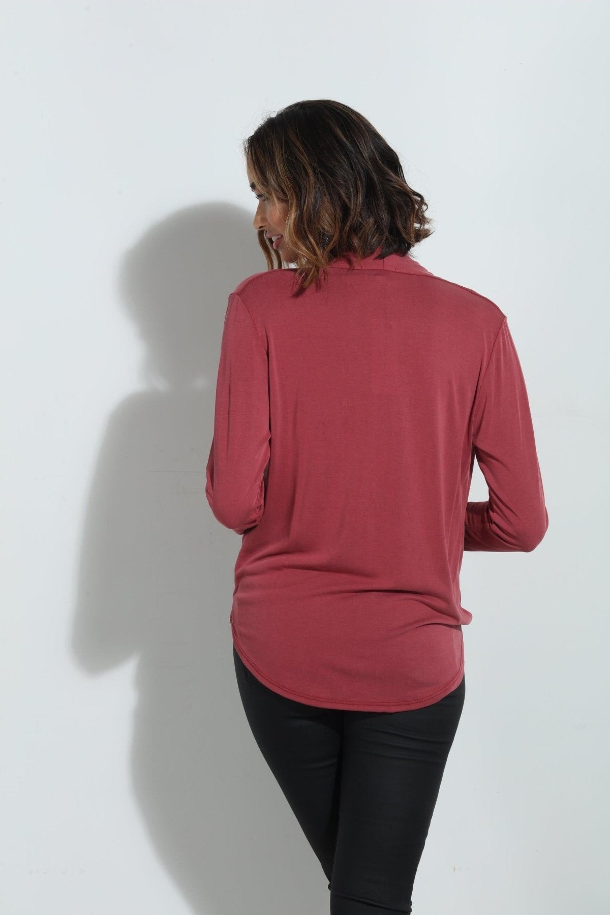 back side of dark mauve long sleeve blouse on woman in dark denim pants