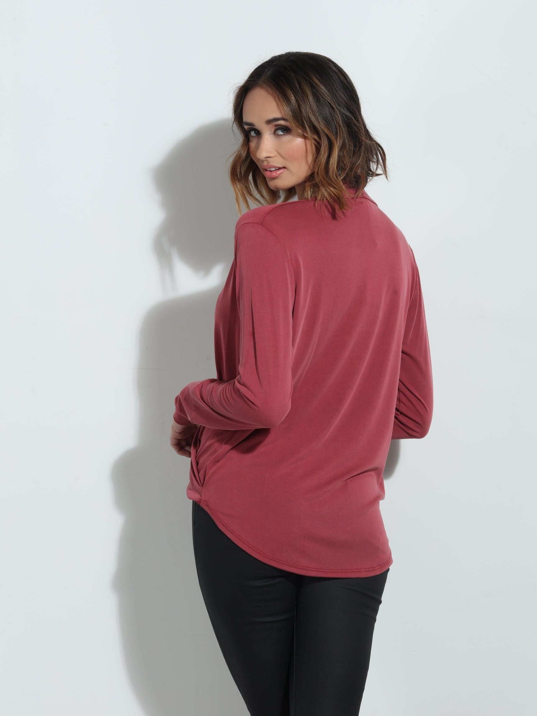 back side of dark mauve long sleeve blouse on woman in dark denim pants
