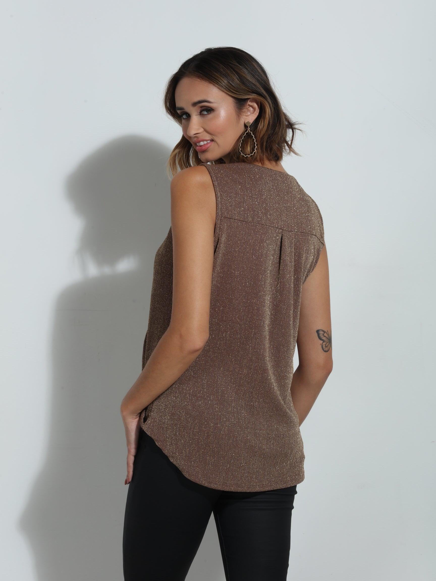 back side of brown sparkle sleeveless blouse on woman in black pants
